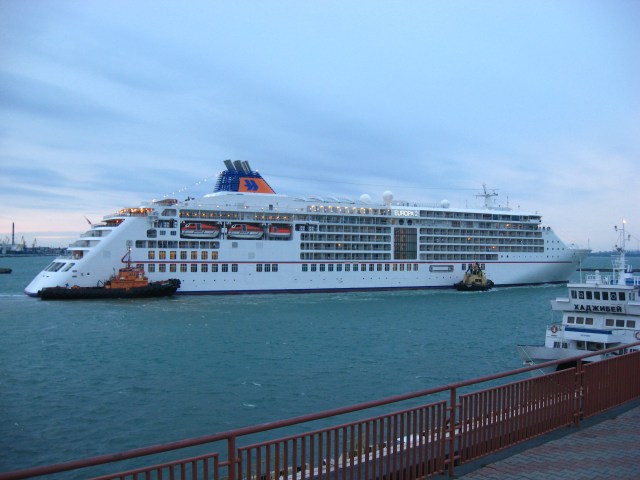 Die Europa 2 flankiert von Schleppern