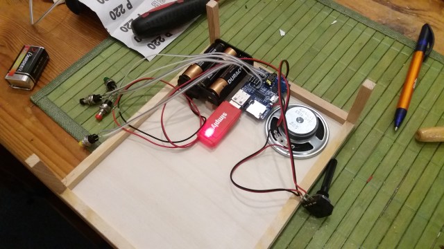 MP3-Player, dessen Stromversorgung, Lautsprecher, Lautstärke und angelötete Steuertaster in der endgültigen Anordnung auf dem Boden der Schublade.